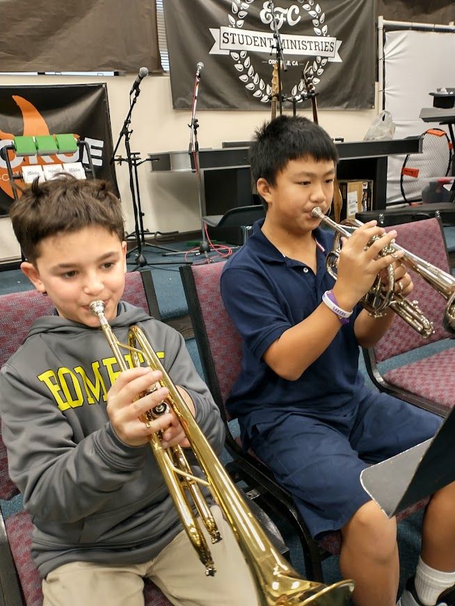 male students playing brass instruments