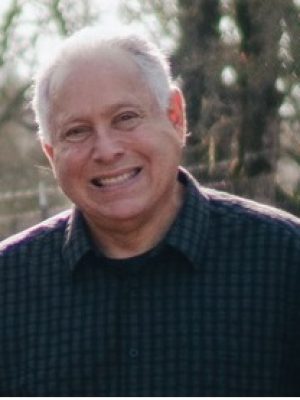 Smiling headshot of Bob Trank outdoors, wearing a dark button-down shirt.