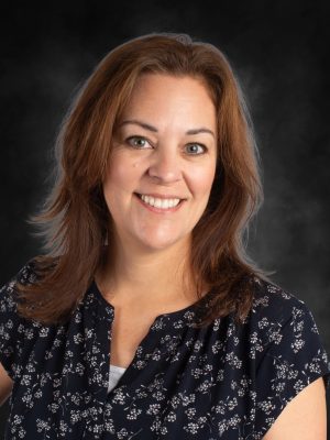 Mrs. Shannon Evans, smiling portrait. Headshot of a woman with auburn hair and a floral top.
